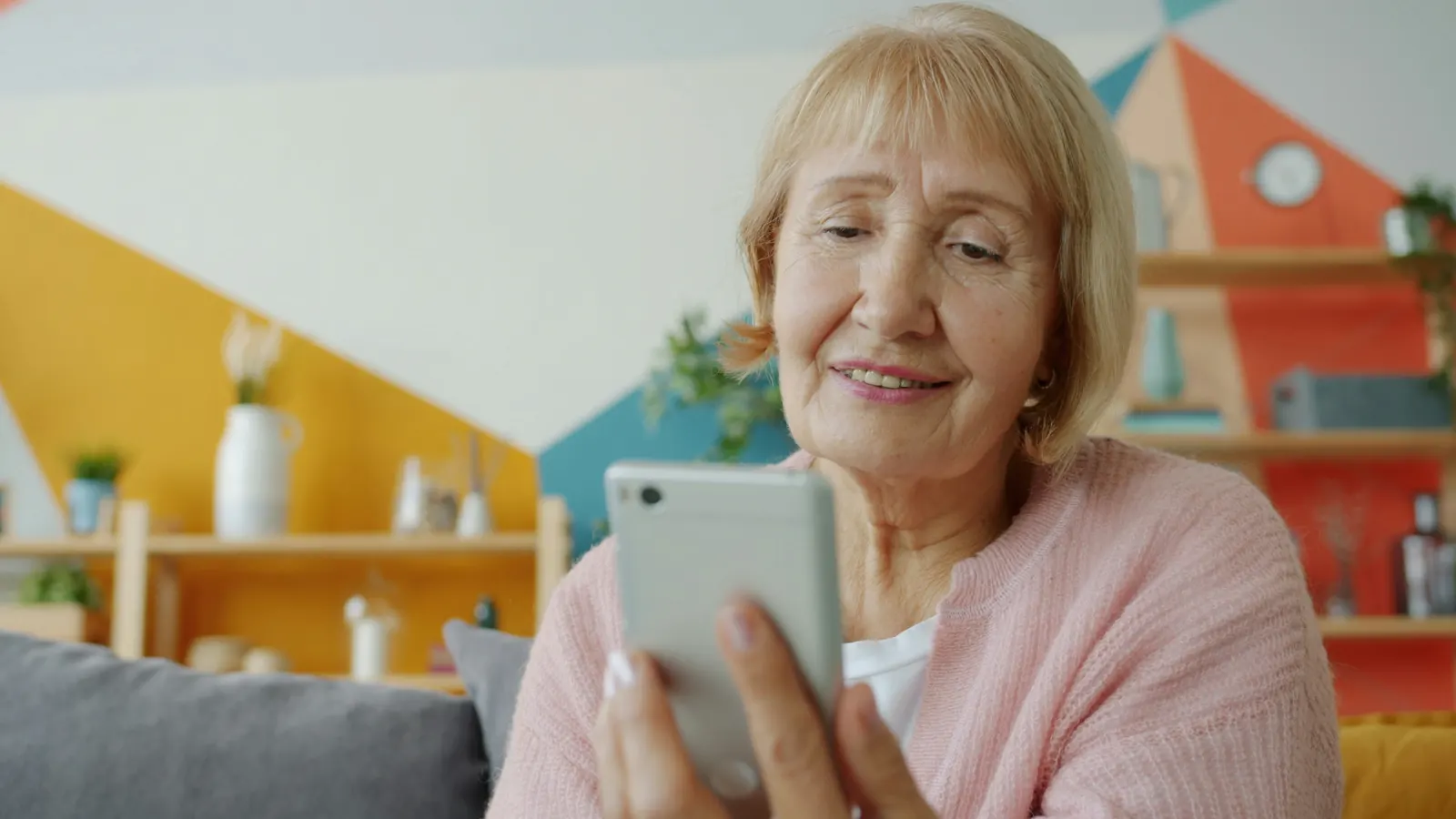 Older woman looking at a mobile phone while sitting at home