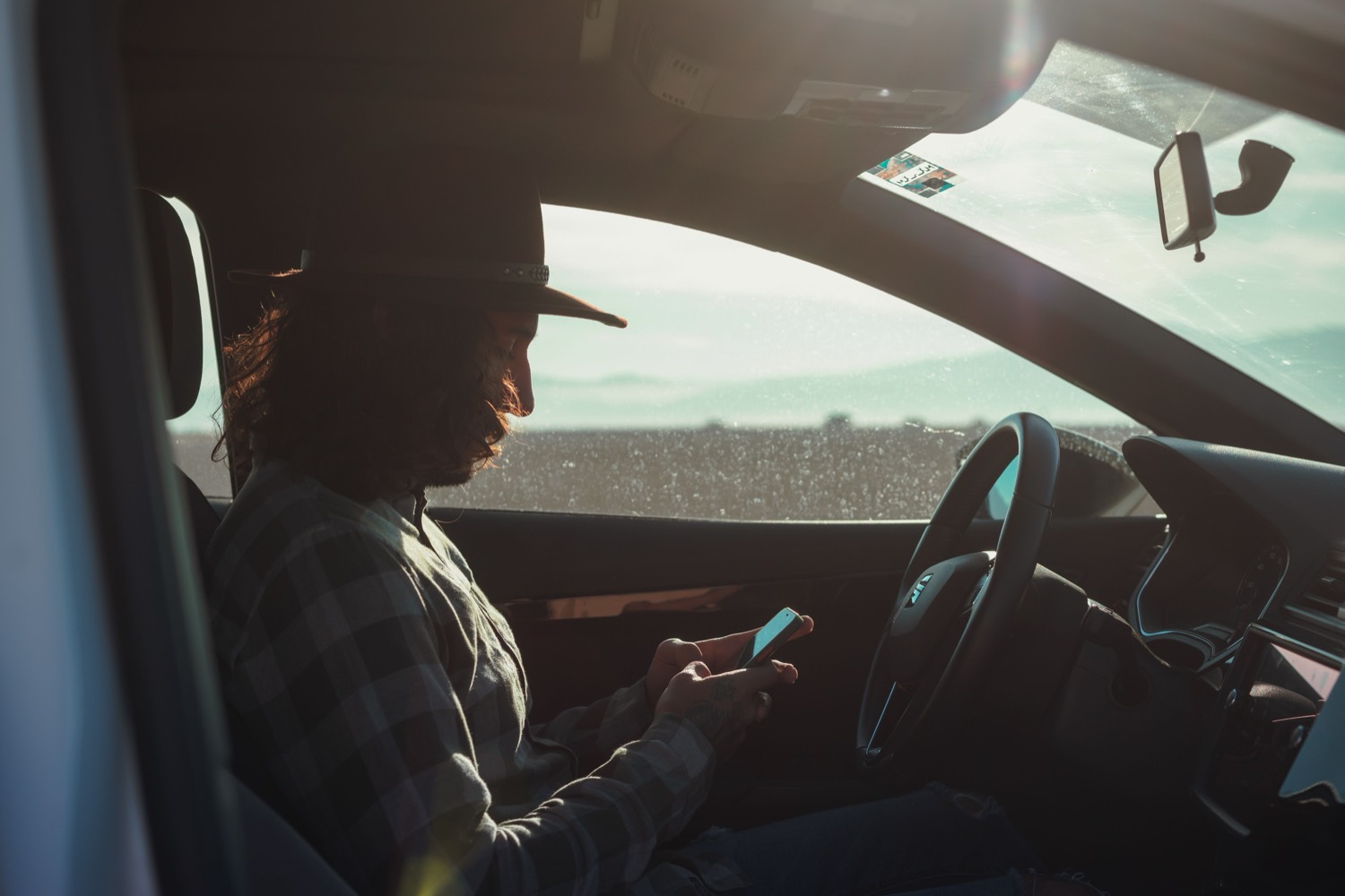 Mobile operator checking a phone from a parked vehicle