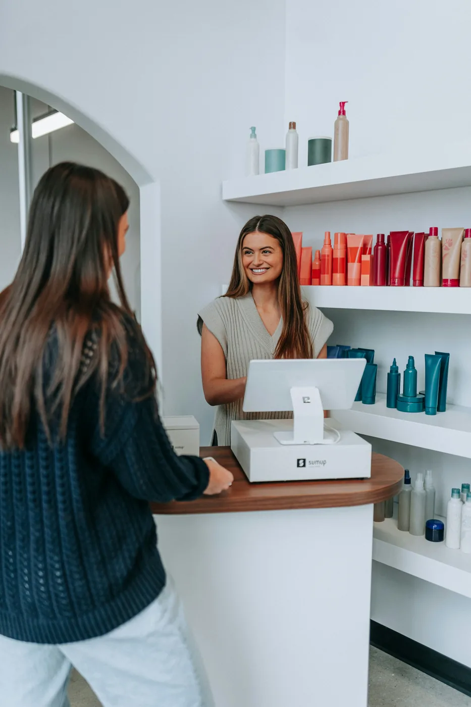 Salon client presenting a payment card at a workstation