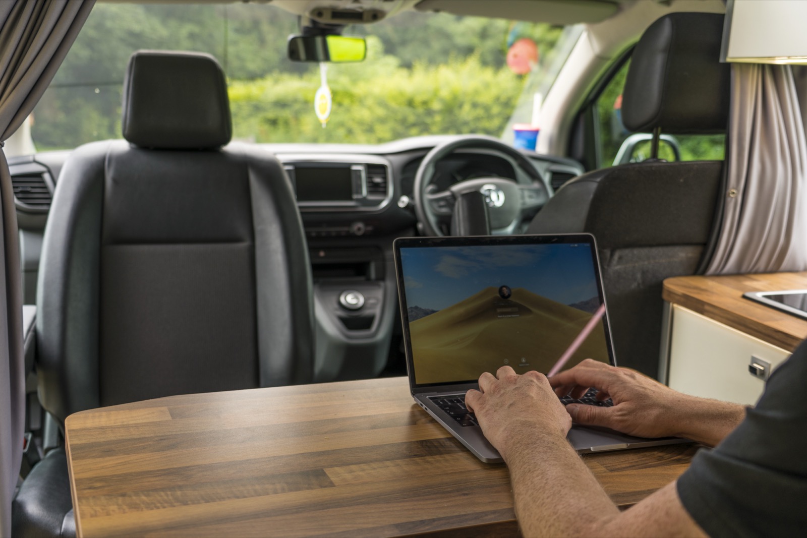 Mobile worker using a laptop inside a vehicle between visits