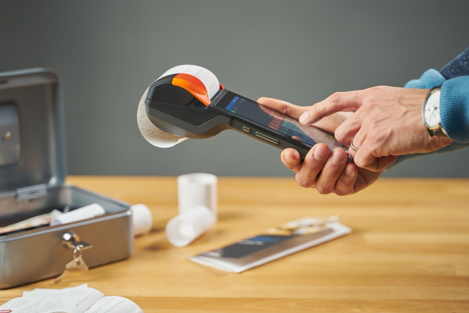 Person using a payment terminal that is printing a receipt