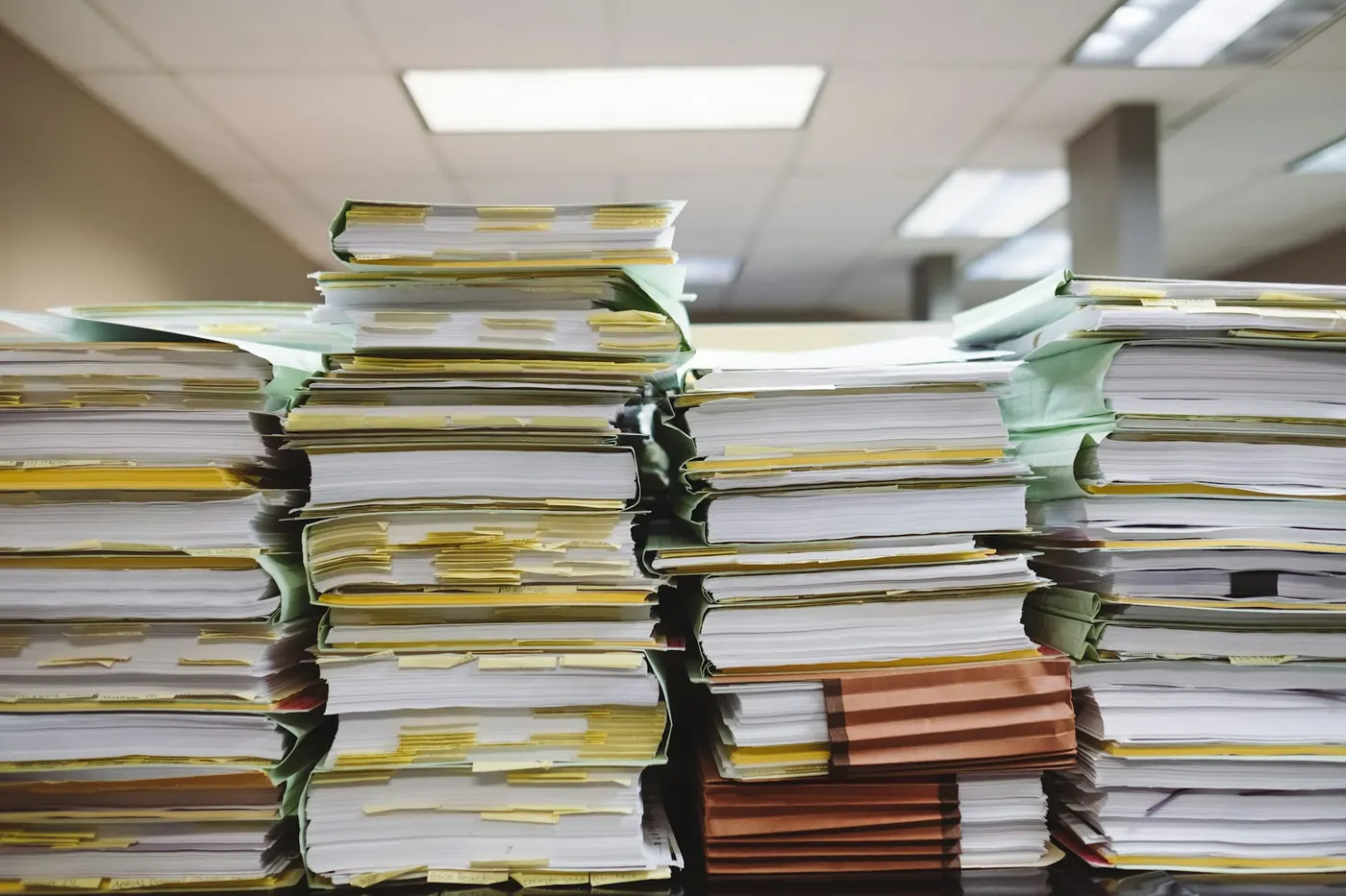 Stacks of business documents and folders on a desk