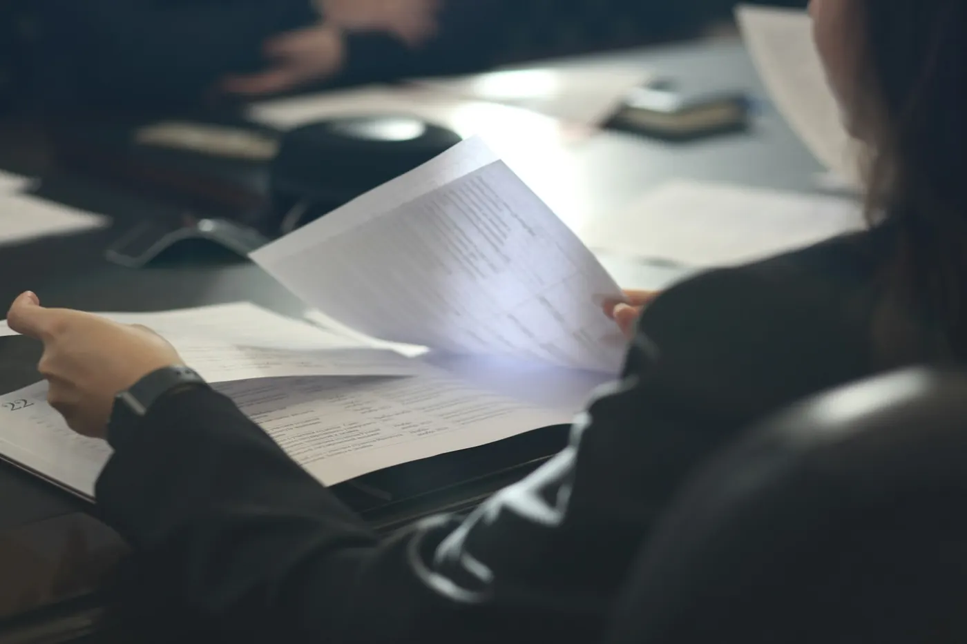 A person reviewing printed business documents at a desk