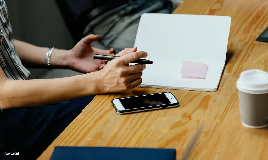 Person writing notes at a meeting table