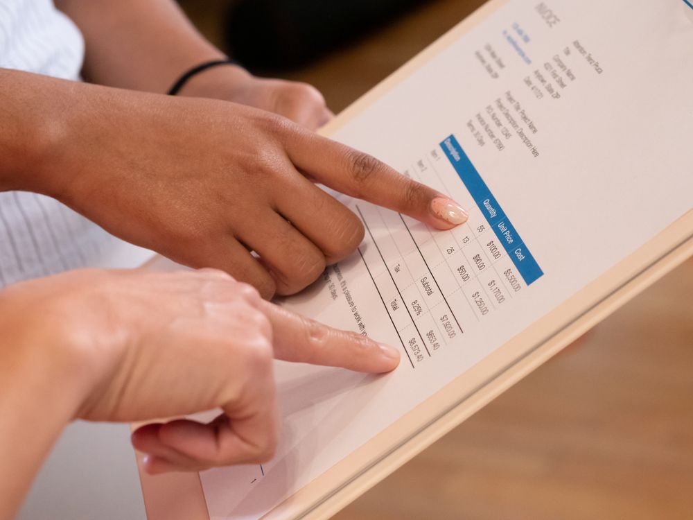 People reviewing numbers on an invoice document