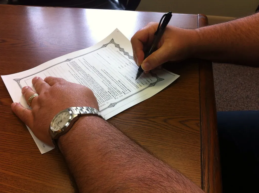 Person signing paperwork on a desk