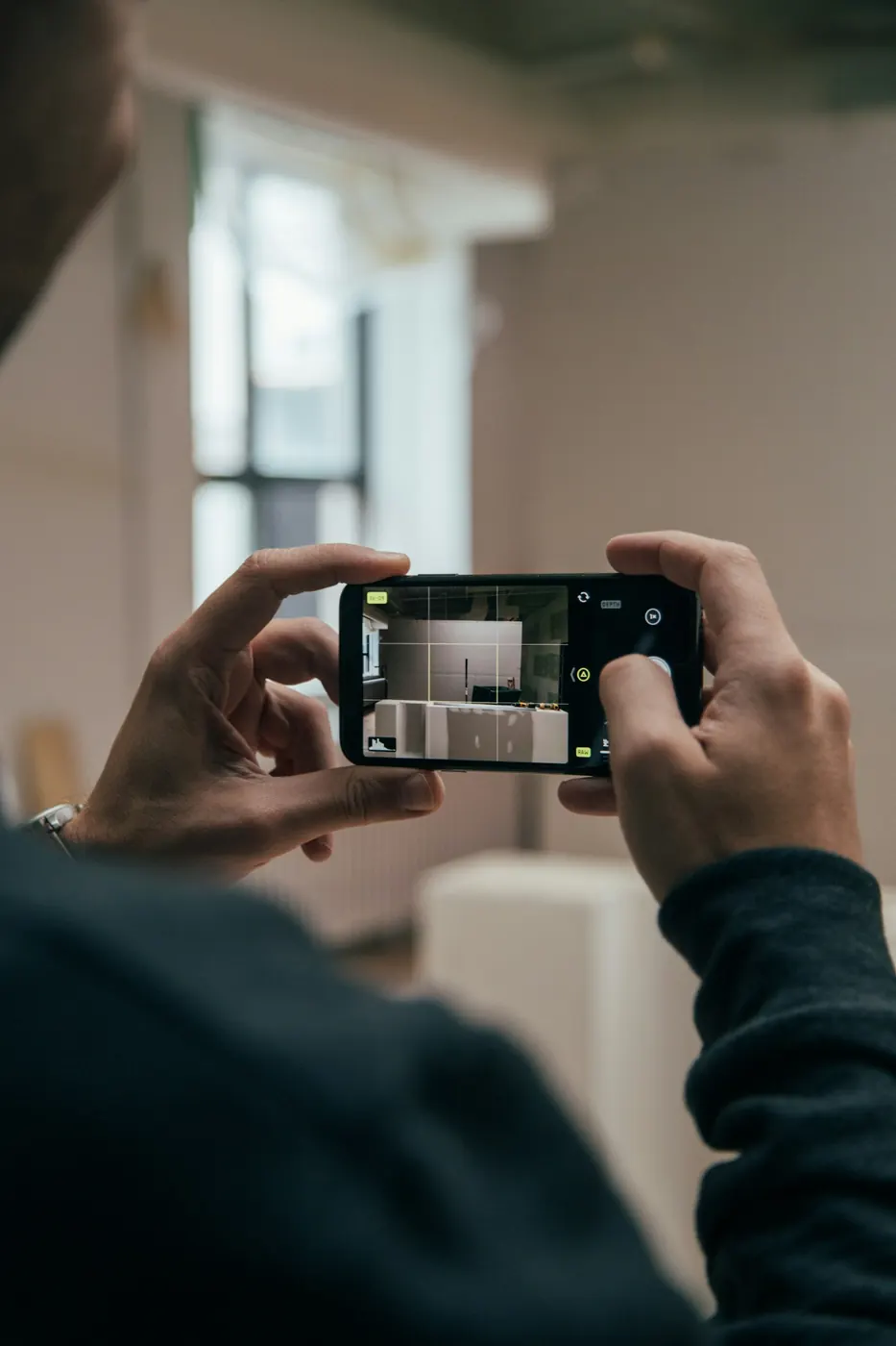 A person photographing an interior space with a phone