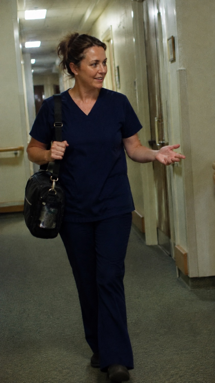 Mobile chiropodist walking through a corridor between appointments