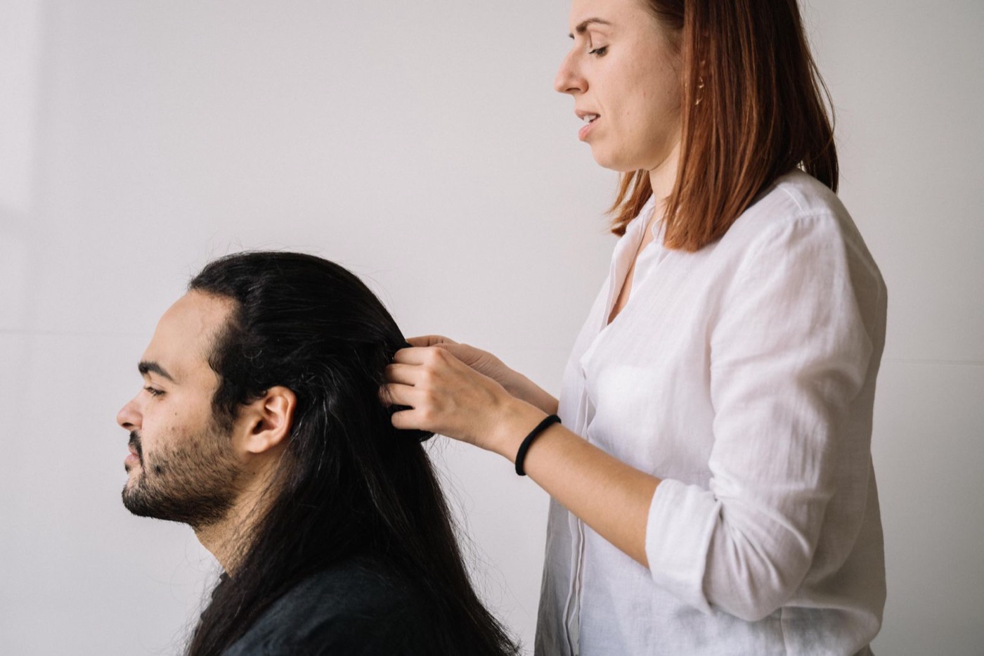 Hairdresser working on a client's hair before recording appointment notes