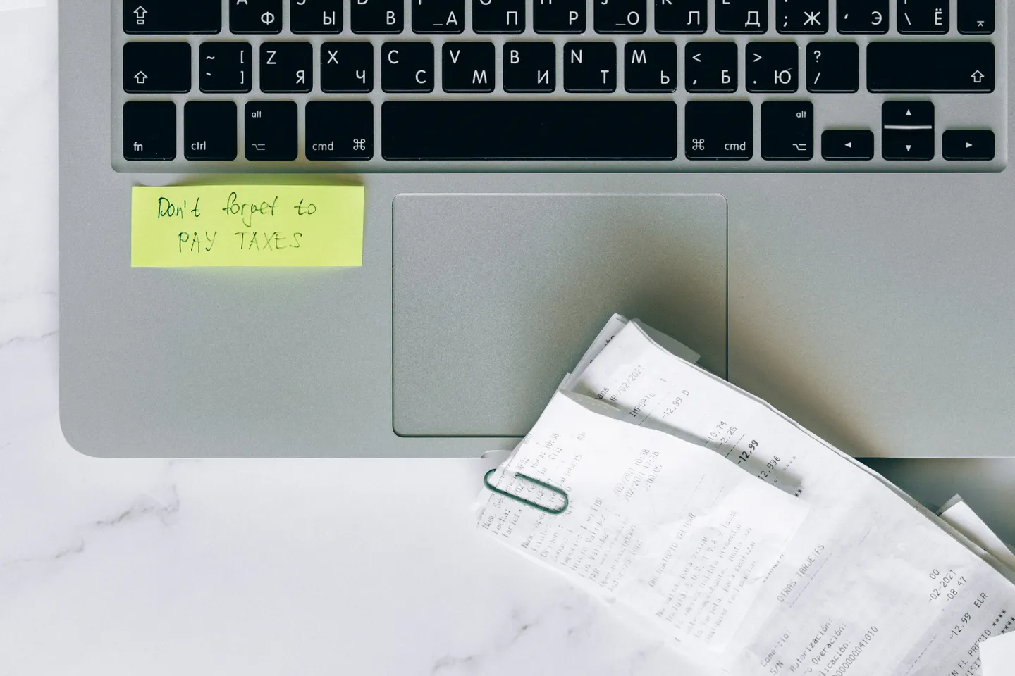 Laptop with tax reminder and receipts arranged for record keeping