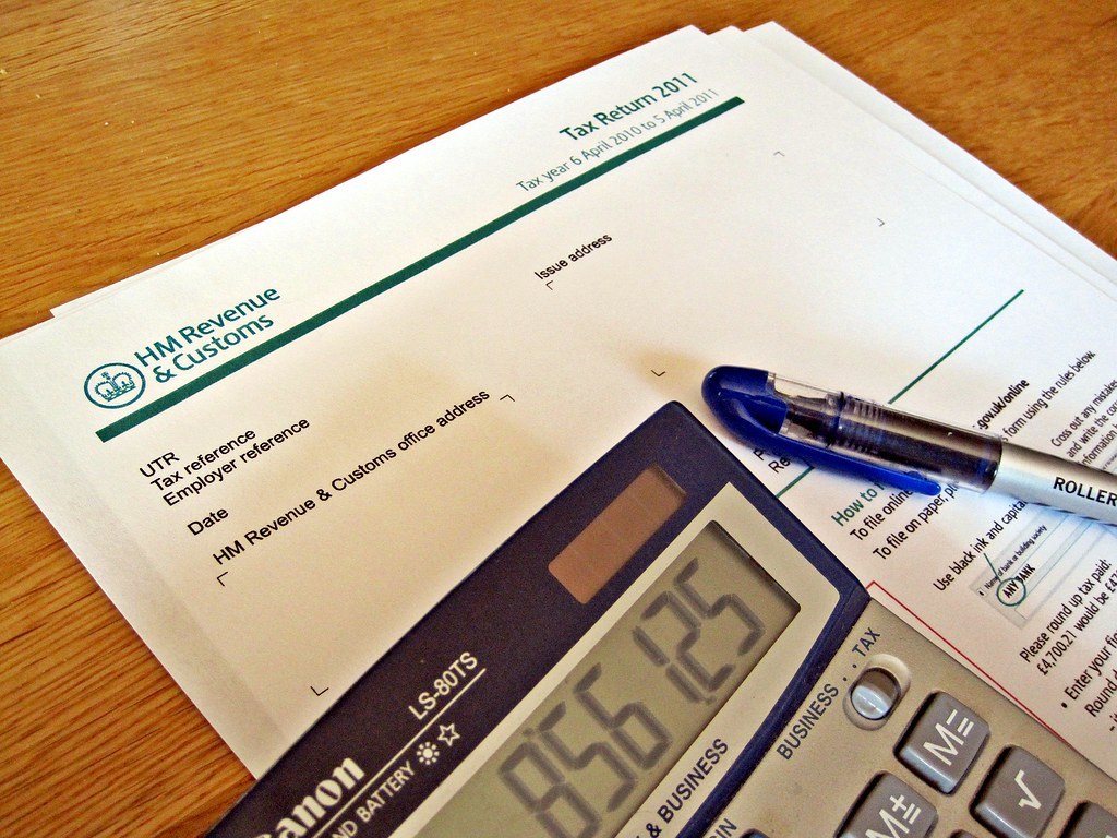 HMRC tax return paperwork with a calculator and pen