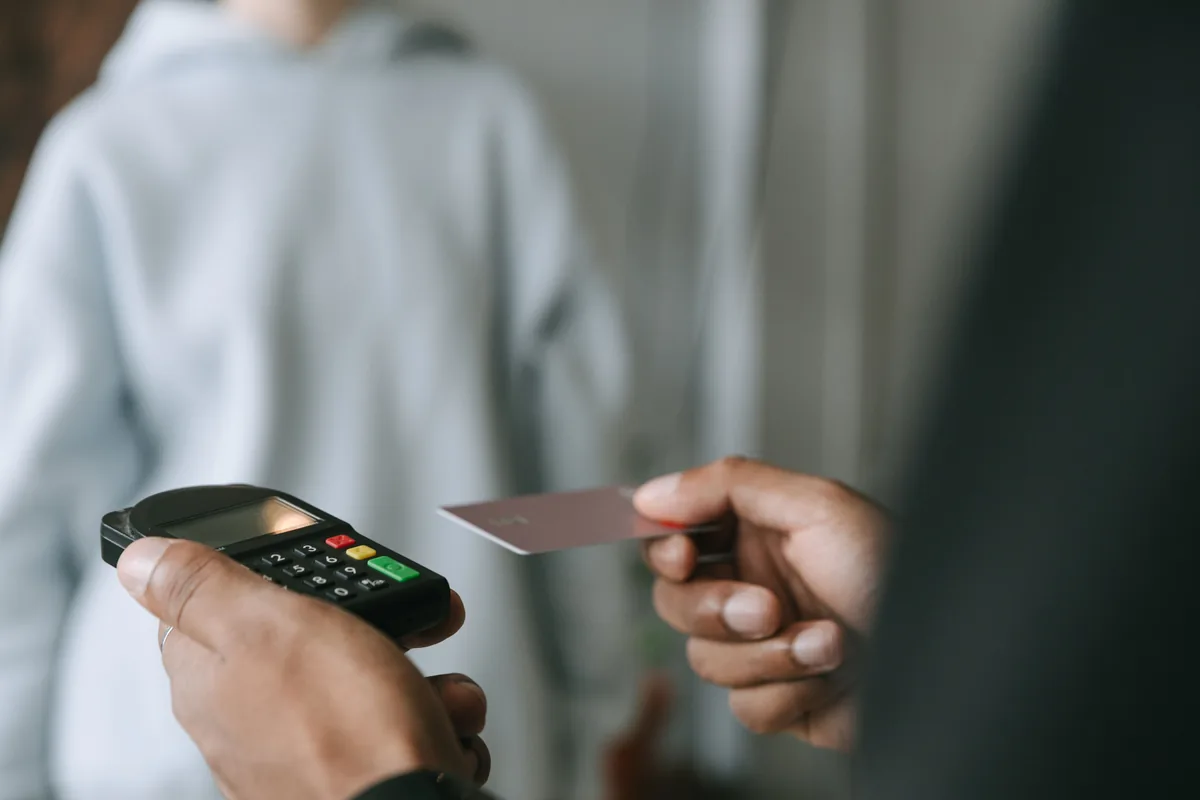 Customer holding a bank card towards a payment terminal