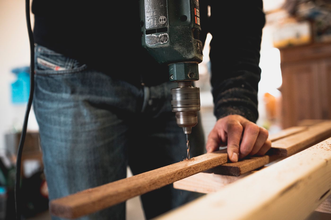 Tradesperson drilling timber during a planned job