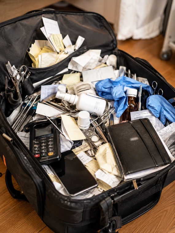 Chiropodist work bag filled with notes, tools, products and loose paperwork