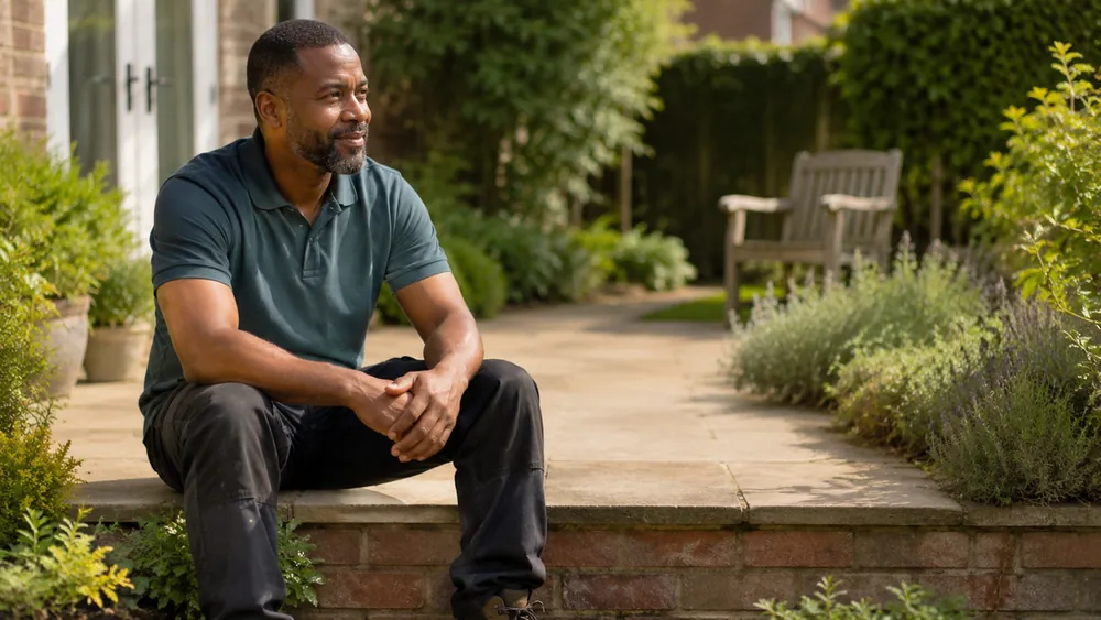 Mobile gardener taking a moment in a client garden between jobs