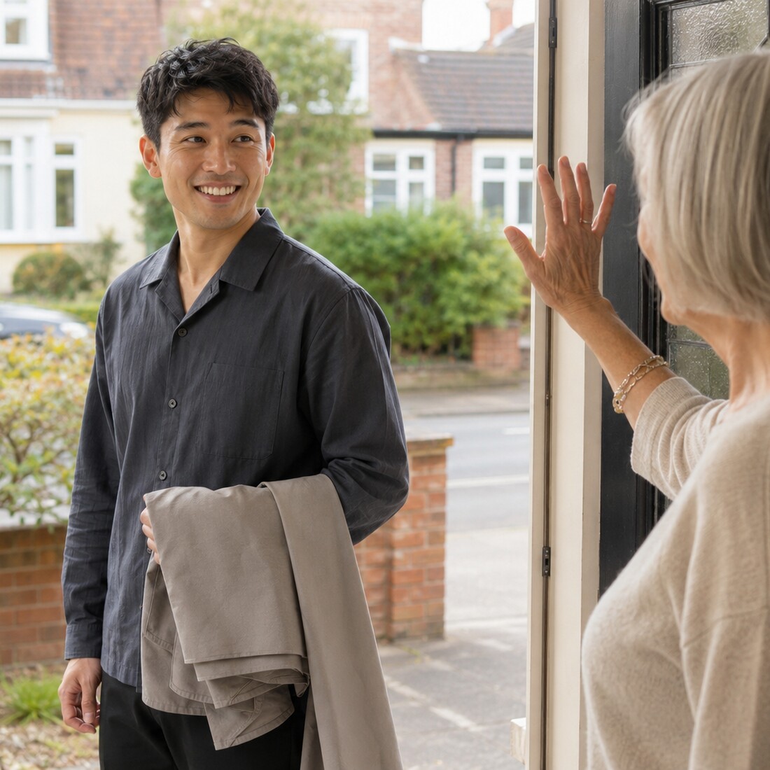 Mobile hairdresser arriving for a home hair appointment with an older client sitting in the living room